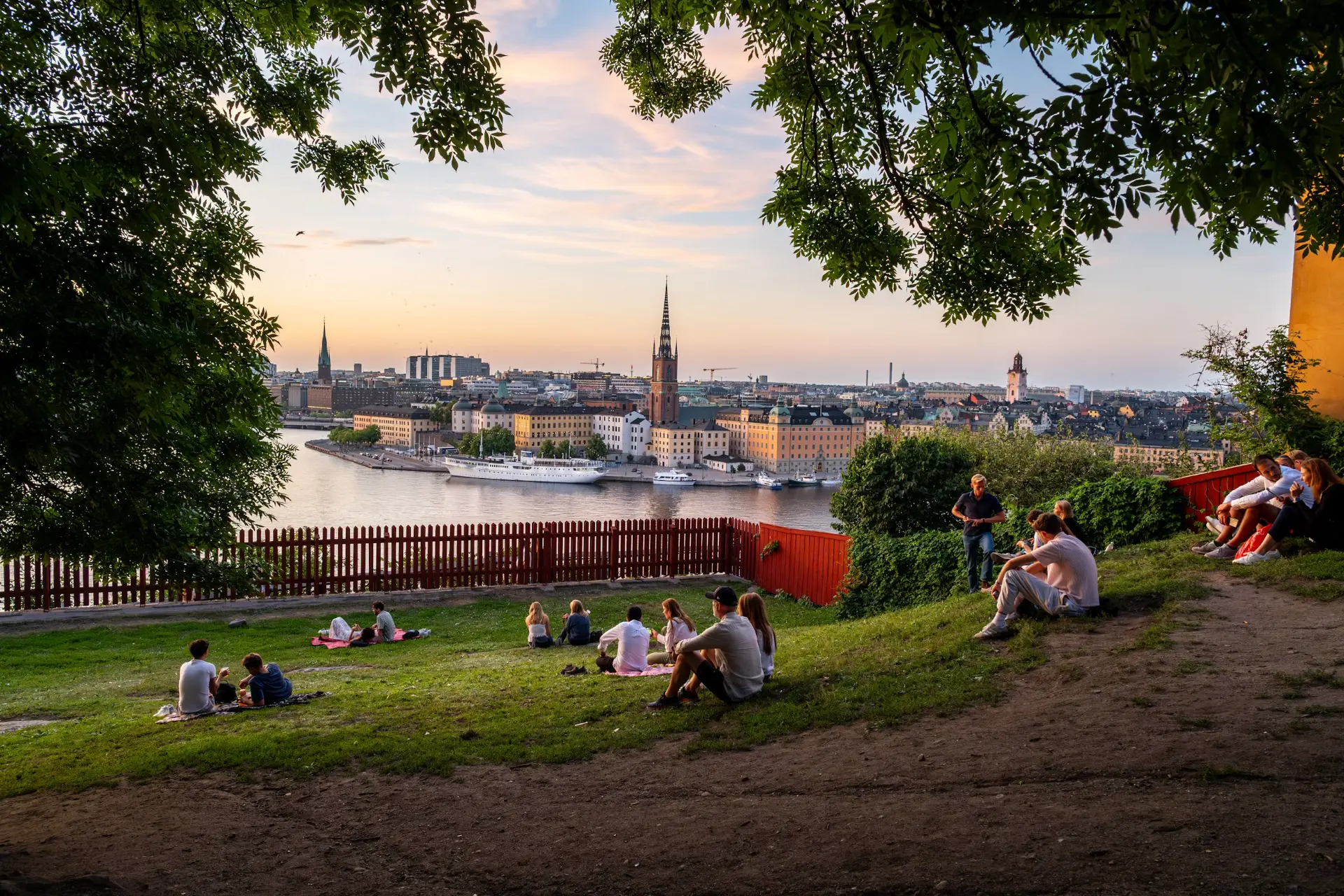 Studenter sitter i solnedgången med utsikt över Stockholm